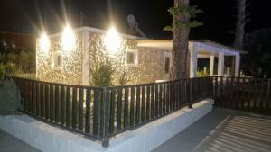 a house with a fence in front of it at night at Aelia House Kefalos - Cozy & Quiet in Kos