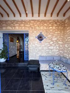 a living room with a couch and a table at Dar Joud Kaouki in Sidi Kaouki