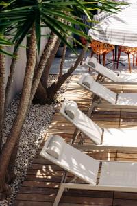 a row of chaise lounges sitting next to trees at Apartmani Pocco Locco in Biograd na Moru