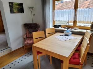 a dining room with a wooden table and chairs at Ferienwohnung Renate in Siegsdorf