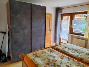 a bedroom with two beds and a gray wall at Ferienwohnung Renate in Siegsdorf