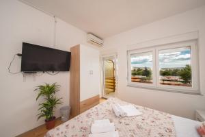 a bedroom with a bed and a flat screen tv at Hotel Riviera in Starigrad