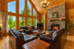a living room with leather furniture and a fireplace at Fiddler Lake Resort - Deer 90 in Mille-Isles