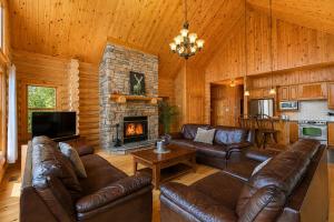 a living room with leather furniture and a fireplace at Fiddler Lake Resort - Deer 90 in Mille-Isles