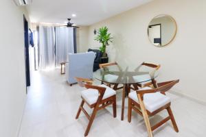 a dining room with a glass table and chairs at Beautiful apartment just 1 block from the beach. in Mazatlán