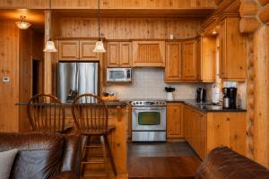a kitchen with wooden cabinets and a stove at Fiddler Lake Resort - Deer 90 in Mille-Isles +16 photos