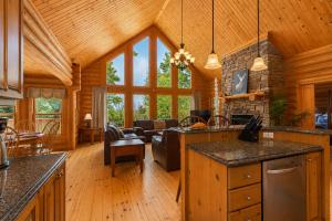 a kitchen and living room in a log cabin at Fiddler Lake Resort - Deer 90 in Mille-Isles
