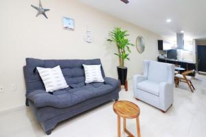 a living room with a blue couch and a chair at Beautiful apartment just 1 block from the beach. in Mazatlán