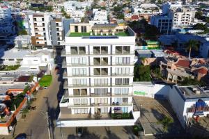 an overhead view of a white building in a city at Beautiful apartment just 1 block from the beach. in Mazatlán +33 photos
