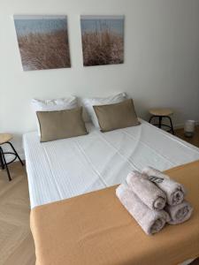a bedroom with a bed with towels on it at Bérylune Centrum in Ostend