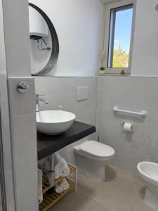 a bathroom with a sink and a toilet and a mirror at Poggio sul Mare in Alberese +9 photos