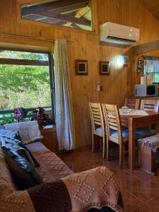 a living room with a table and chairs and a kitchen at Parcela Peumayen casa 2 in Pucura