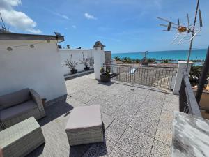 a patio with a couch and a view of the ocean at HH Moneglia La Caletta in Moneglia