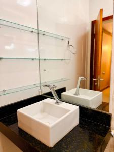 a bathroom with a white sink and a mirror at Apartamento de 2 Quartos no Centro in Imperatriz +21 photos