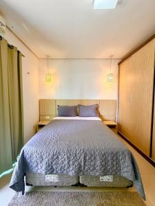 a bedroom with a large bed with blue pillows at Apartamento de 2 Quartos no Centro in Imperatriz