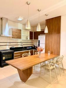 a large kitchen with a wooden table and chairs at Apartamento de 2 Quartos no Centro in Imperatriz