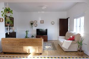 a living room with a couch and a tv at Vila Glória Guesthouse in Lagos