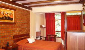 a bedroom with a bed and a brick wall at Andina Principal in Machu Picchu