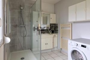 a bathroom with a shower and a washing machine at Family House in Caudry