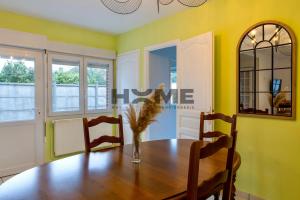 a dining room with a wooden table and yellow walls at Family House in Caudry