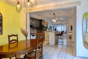 a dining room and kitchen with a table and chairs at Family House in Caudry +20 photos