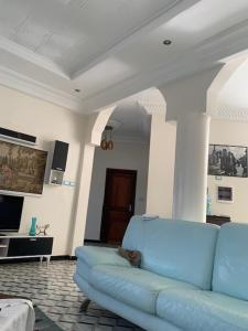 a living room with a blue couch in a room at Le Wallo - Residence Sebi in Sébikhoutane