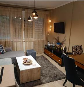 a living room with a bed and a table and a desk at Dimitris Apartment in Karditsa