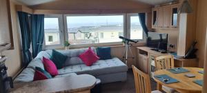 a living room with a couch and a table at Eyemouth Caravan in Eyemouth
