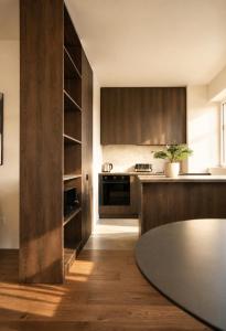 a kitchen with wooden cabinets and a table at The Loft, An Architects Dream in Târgu-Mureş