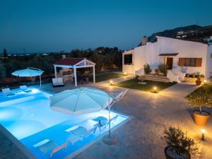 a villa with a swimming pool at night at Villa Aelia Kefalos-Private & Spacious with Pool in Kámpos