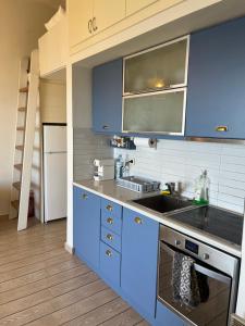 a kitchen with blue cabinets and a sink at Daphne Glyfada Corfu in Glyfada +33 photos
