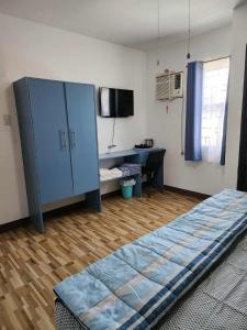 a bedroom with a blue cabinet and a desk at Domus Florum Travellers Inn in Legazpi +24 photos