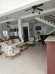 a living room with a couch and chairs and a piano at Domus Florum Travellers Inn in Legazpi