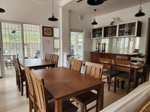 a kitchen and dining room with wooden tables and chairs at Domus Florum Travellers Inn in Legazpi