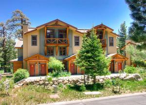 a large house with a tree in front of it at Cabins 13 in Old Mammoth