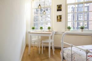 a white table and chairs in a room with windows at Spui's the Limit in Amsterdam