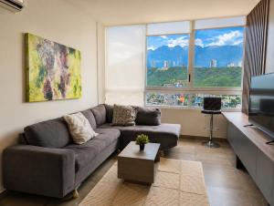 a living room with a couch and a tv at Stylish Panoramic Views City Loft in Monterrey