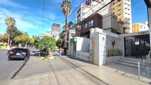 a street with a car parked next to a building at Apartamento EL PRADO de lujo in Cochabamba