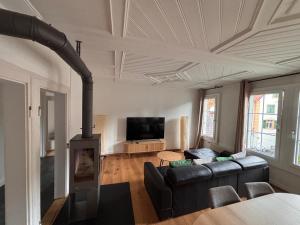 a living room with a black couch and a fireplace at Villa Epoka in Interlaken