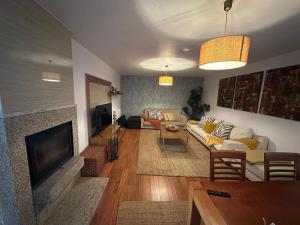 a living room with a couch and a fireplace at Casa Encosta da Caniçada in Vieira do Minho