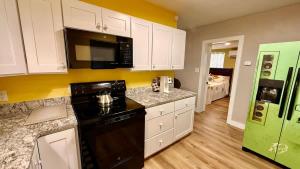a kitchen with white cabinets and a black appliance at Charming Citrus in Inverness