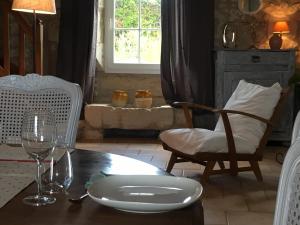 a table with a plate and a glass of wine at Le Marancènes in Laroque-Timbaut
