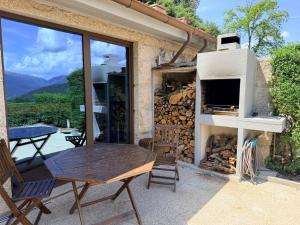 a patio with a wooden table and a fireplace at Casa Encosta da Caniçada in Vieira do Minho