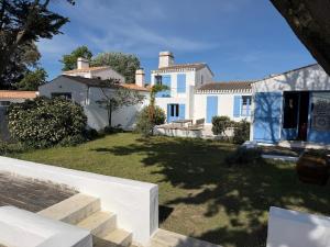 a large white house with a yard at Charmante maison front de mer avec jardin in La Guérinière