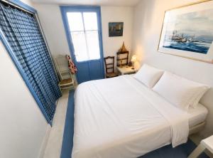 a bedroom with a white bed and a window at Charmante maison front de mer avec jardin in La Guérinière