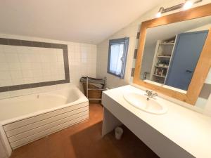 a bathroom with a tub and a sink and a bath tub at Charmante maison front de mer avec jardin in La Guérinière