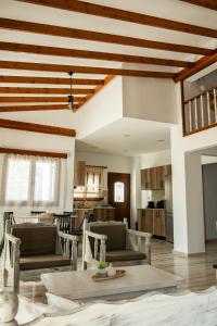 a living room with wooden ceilings and a table and chairs at Villa Aelia Kefalos-Private & Spacious with Pool in Kámpos