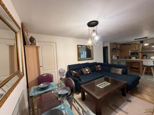 a living room with a blue couch and a table at Disney Harmony Flat in Saint-Thibault-des-Vignes +16 photos