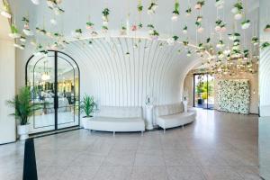 a lobby with two white couches and flowers on the ceiling at Cruise Hotel in Tbilisi City
