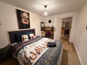 a bedroom with a bed with a painting on the wall at Disney Harmony Flat in Saint-Thibault-des-Vignes